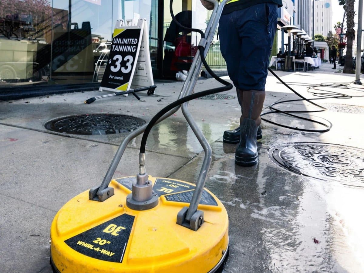 Surface cleaner pressure washing a concrete sidewalk